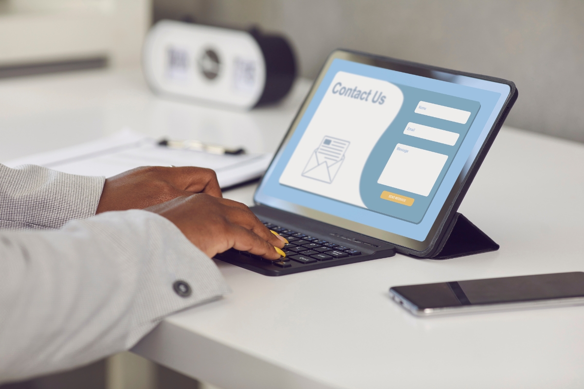 A person typing on a laptop with a sign-up form for "What is a sales funnel" on it.