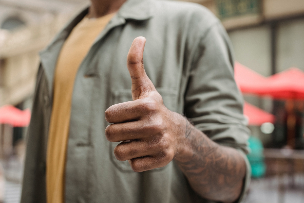 A person displaying a thumbs-up gesture in support of word of mouth marketing.