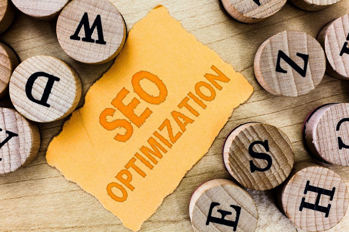 The word SEO optimization is written on a piece of wood.