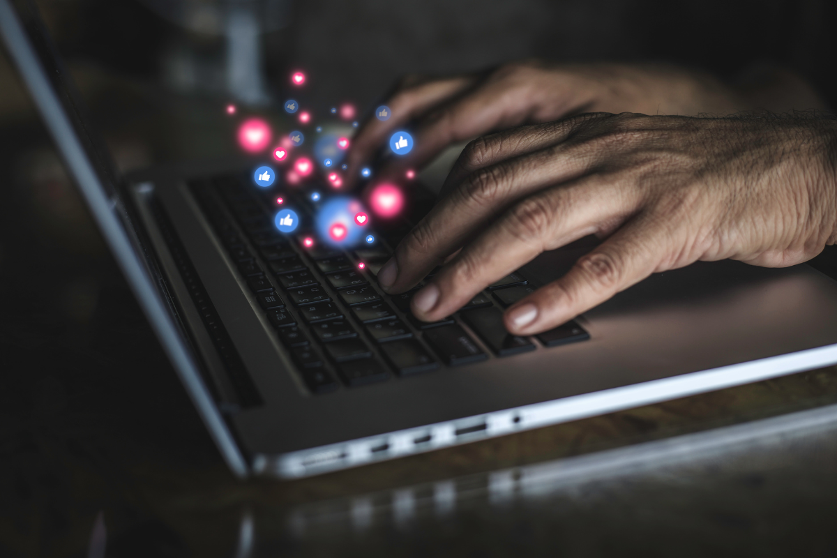 A man's hands typing on a laptop with social media icons for WordPress plugins.