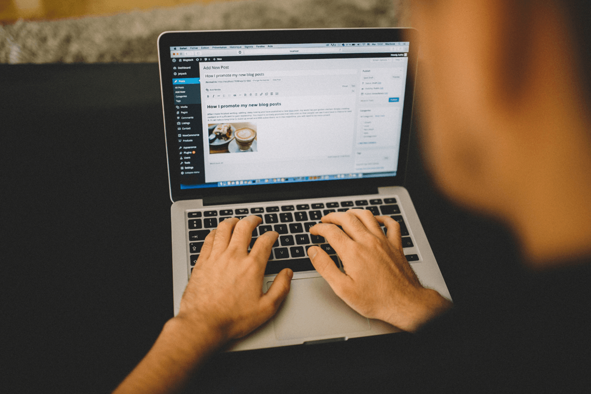 A person typing on a laptop with a WordPress website.