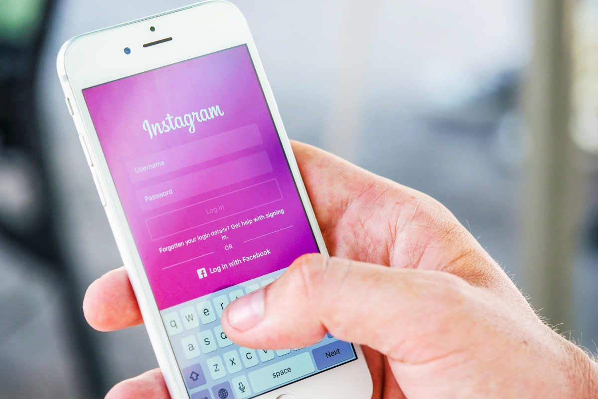 A person's hand holding a smartphone displaying the Instagram login screen, focusing on the username and password fields for Instagram marketing tips.