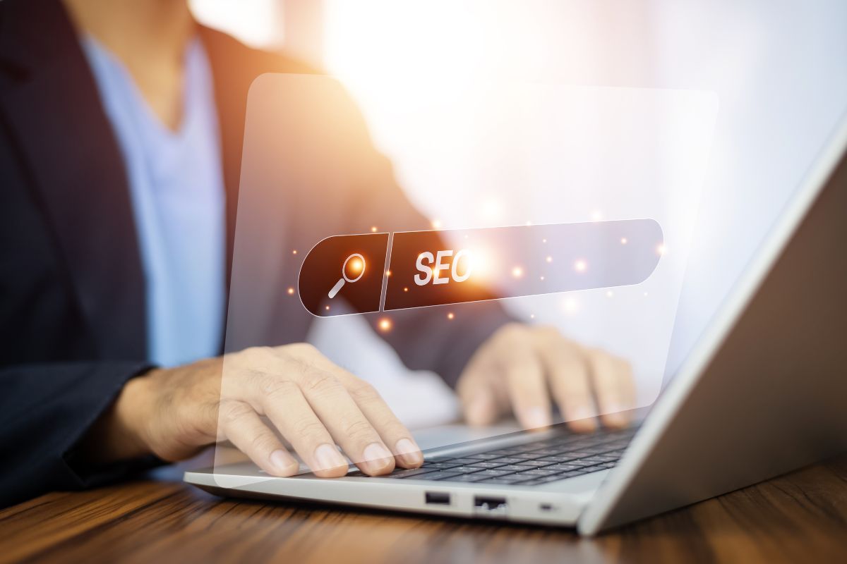 A person's hands typing on a laptop with a digital overlay displaying the term "Rank Math SEO" with an icon of a magnifying glass.