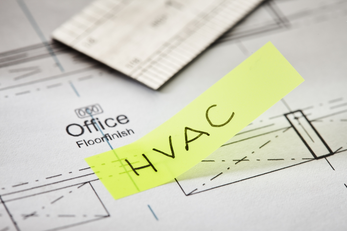 A yellow sticky note with "HVAC" written on it, strategically placed on architectural plans labeled "Office" and "Floor Finish," serves as a crucial element in the community marketing strategy.