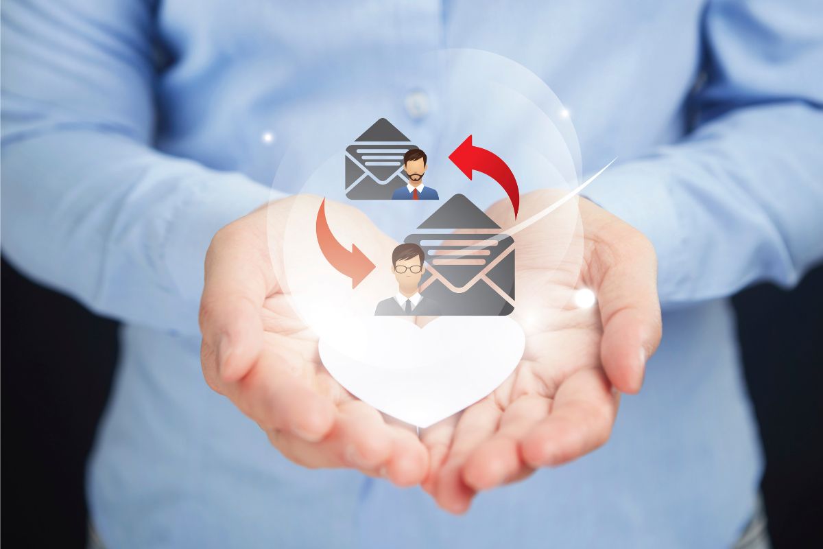 Hands holding icons of two people exchanging emails, represented by envelopes and red arrows, signifying communication or a drip campaign.