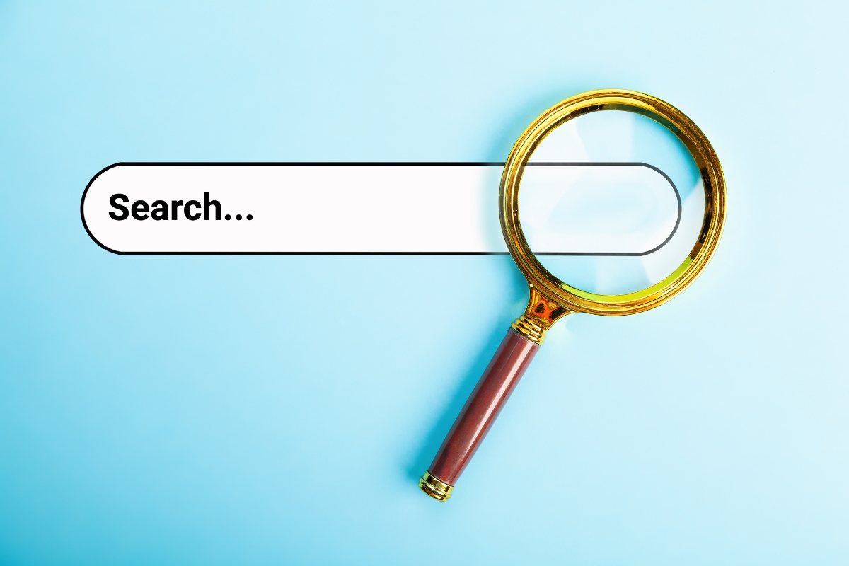 A magnifying glass enlarges the word "Search..." inside a search bar on a light blue background, reminiscent of exploring "what is Ecosia search engine.