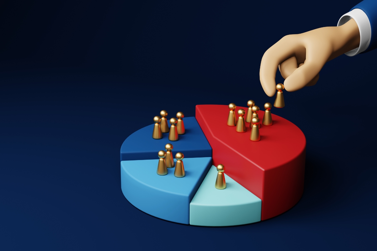 A 3D hand places a pawn on a multicolored pie chart with other pawns already positioned on it, visually answering the question: What Is Market Segmentation? This scene represents the distribution or allocation of resources or data among different segments.