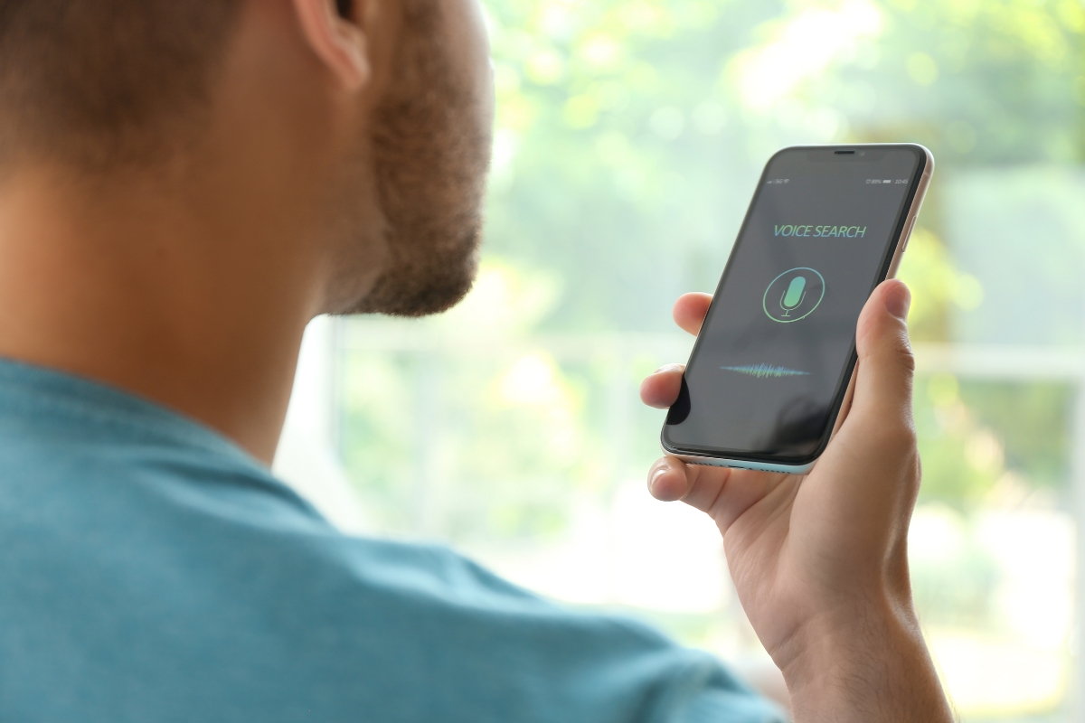 A person holding a smartphone with the voice search function activated on the screen, exploring insights on how to optimize your website for voice search.