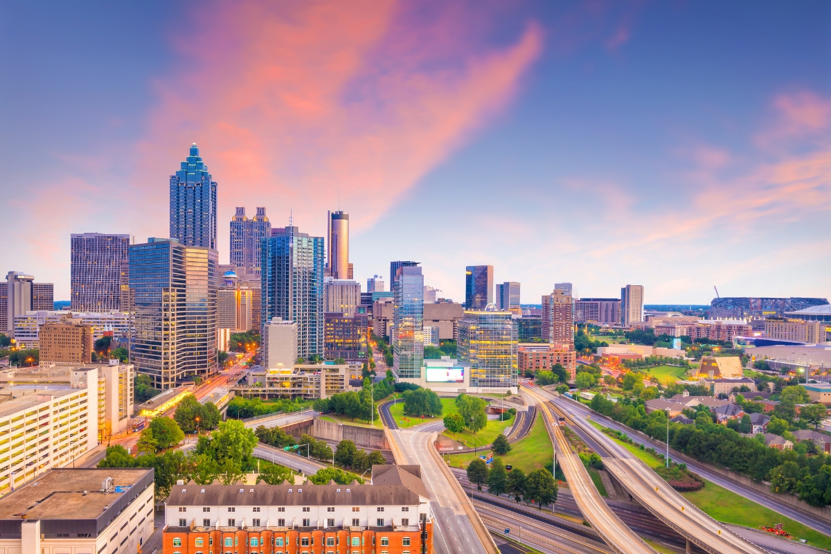 Aerial view of Atlanta, Georgia's downtown skyline at sunset, featuring high-rise buildings, highways, green spaces, and a perfect backdrop for learning how to market your small business effectively.