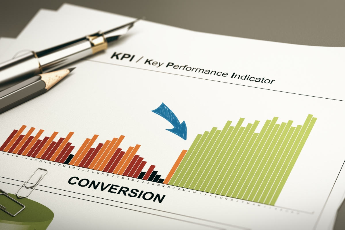 Close-up of a document showcasing a KPI chart with a blue arrow highlighting an increase in conversion rates, attributed to personalized content strategies. A pen and paperclip are placed on the document.