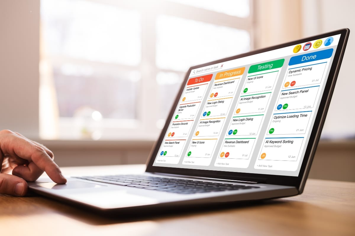 A person interacts with a laptop displaying a colorful project management dashboard, seamlessly integrating a content calendar. The columns labeled To Do, In Progress, Testing, and Done ensure efficient planning and organization.