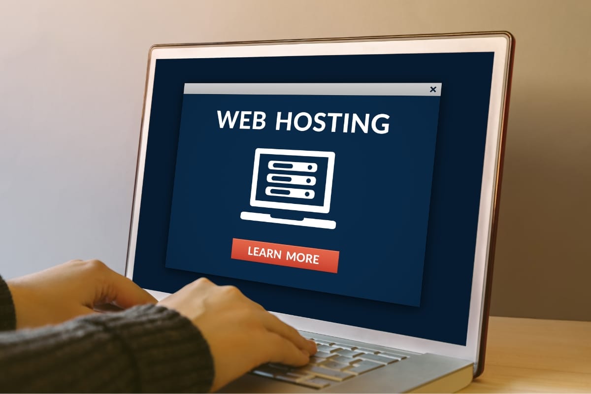 A person using a laptop with a "Web Hosting" window featuring a "Learn More" button is also exploring the benefits of WordPress backup.