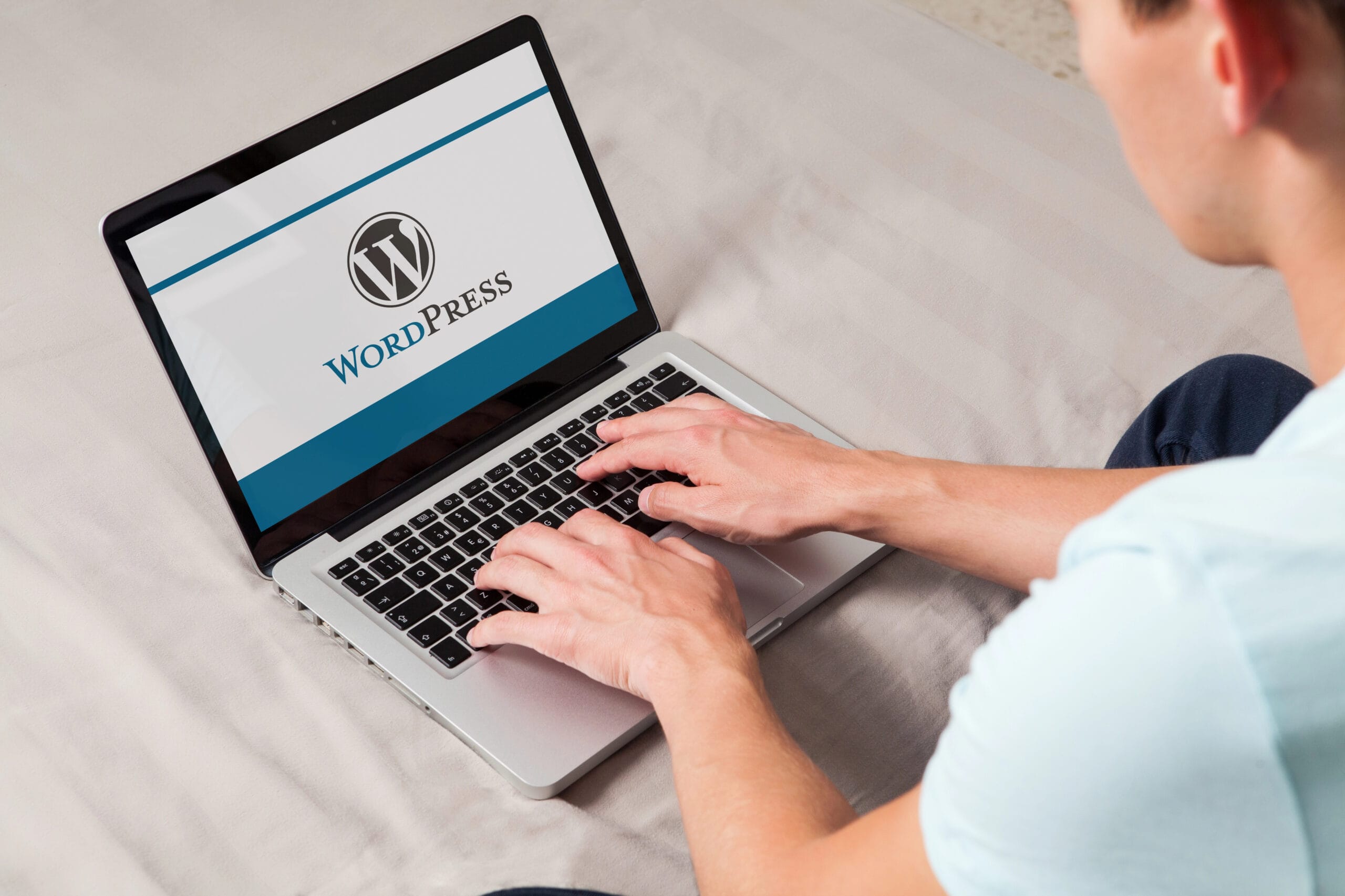 A person diligently typing on a laptop showcasing the WordPress logo and interface, armed with the knowledge of WordPress security best practices to ensure a safe and efficient blogging experience.