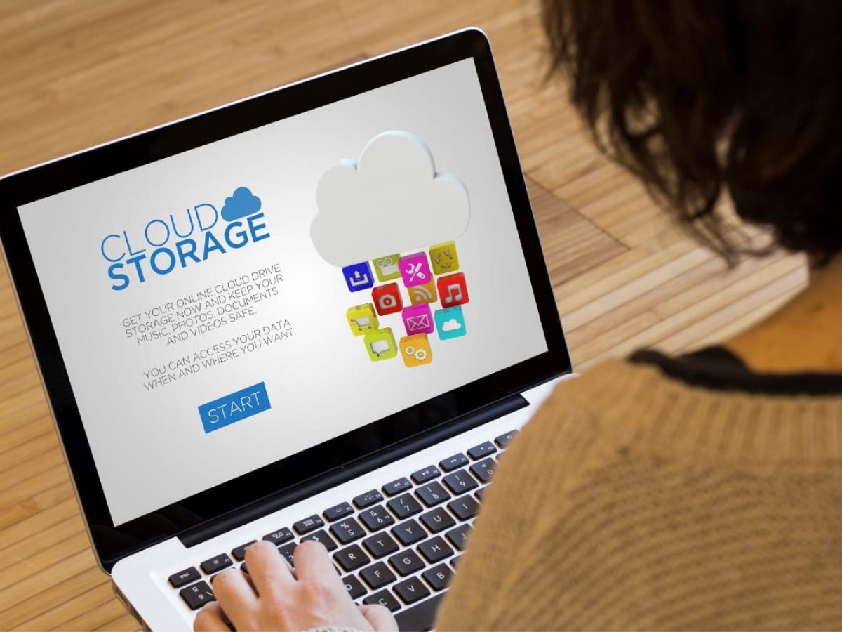 A person uses a laptop showcasing a cloud storage application, prominently featuring a start button and details about online file access through advanced cloud backup services.