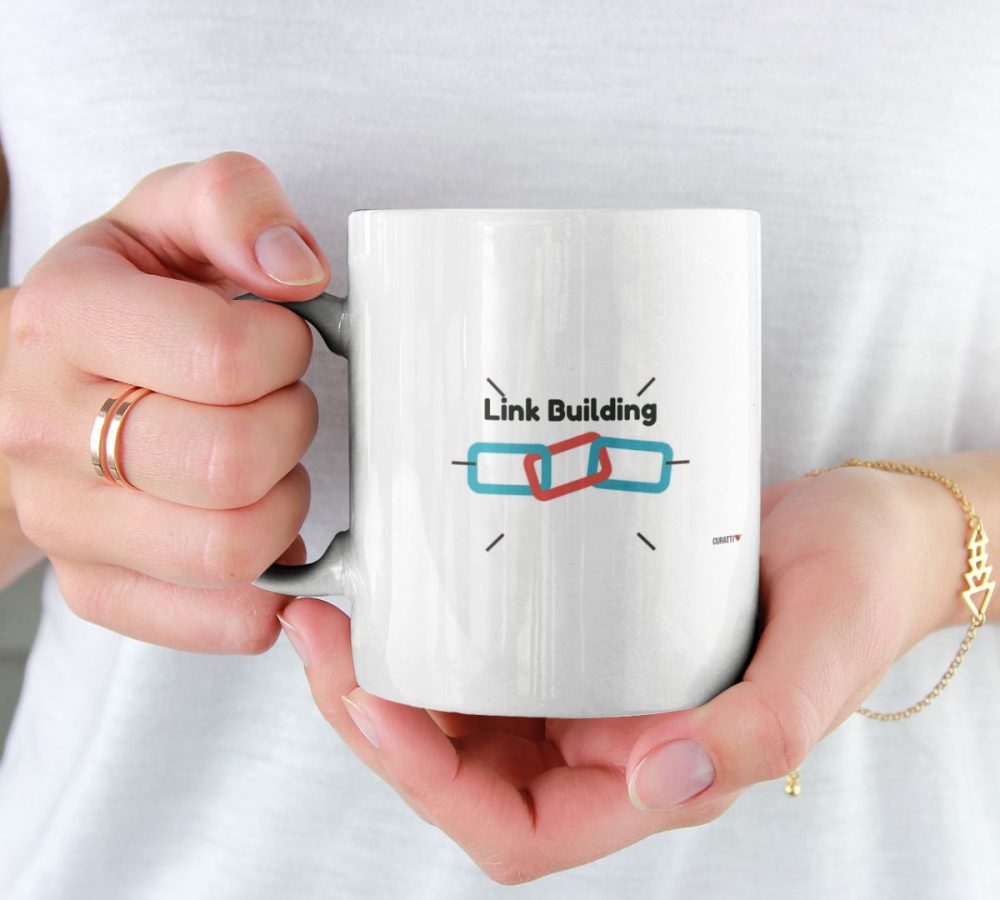 A woman holding a coffee mug that says SEO link building.